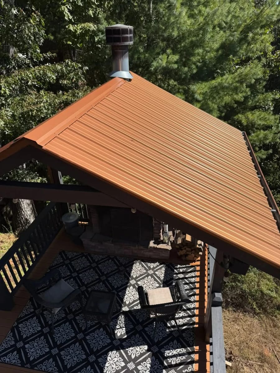 Copper metal roof over a covered patio with a stone fireplace, seen from above