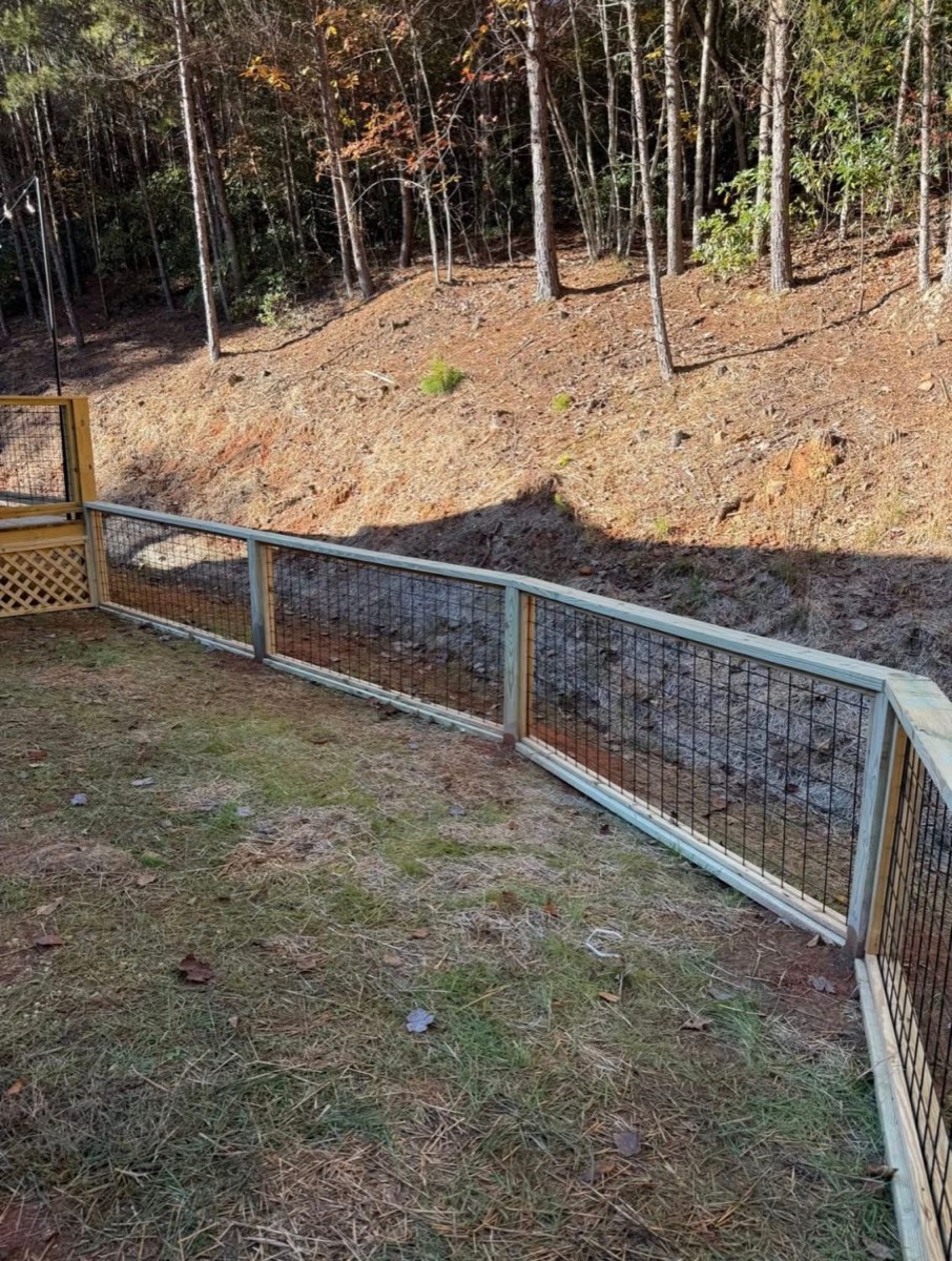 Wire-panel fence stepping along a sloped yard