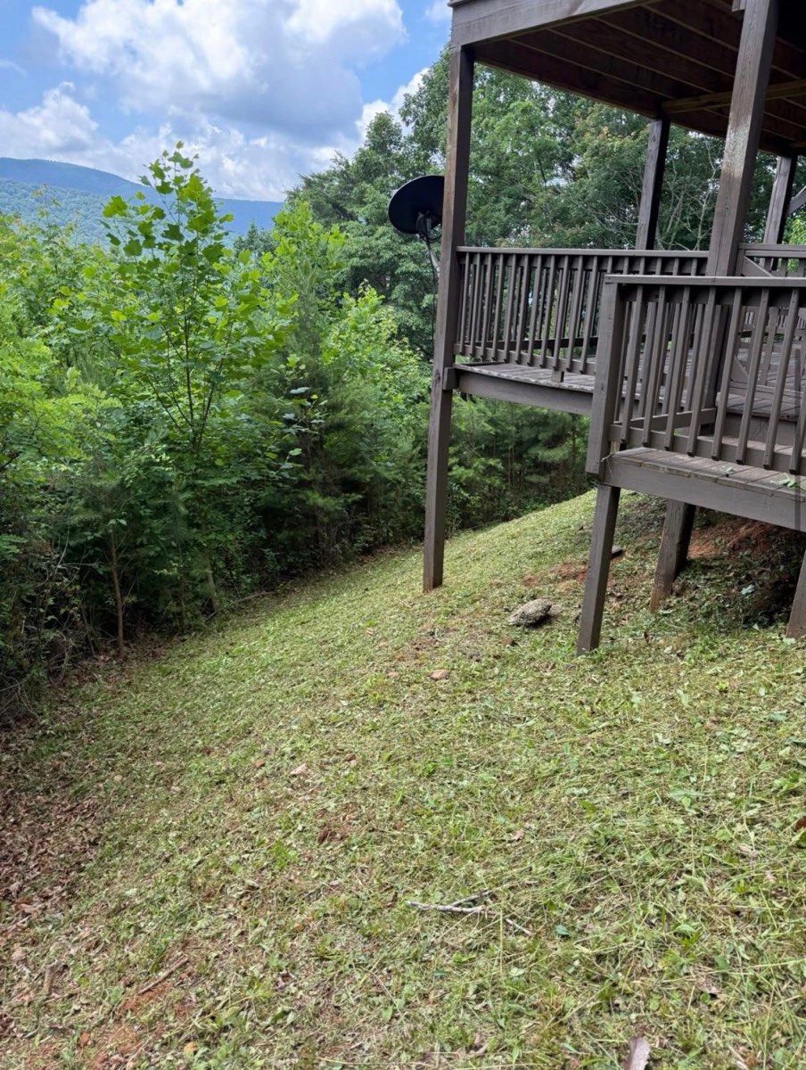 After: steep slope under the deck mowed short and even