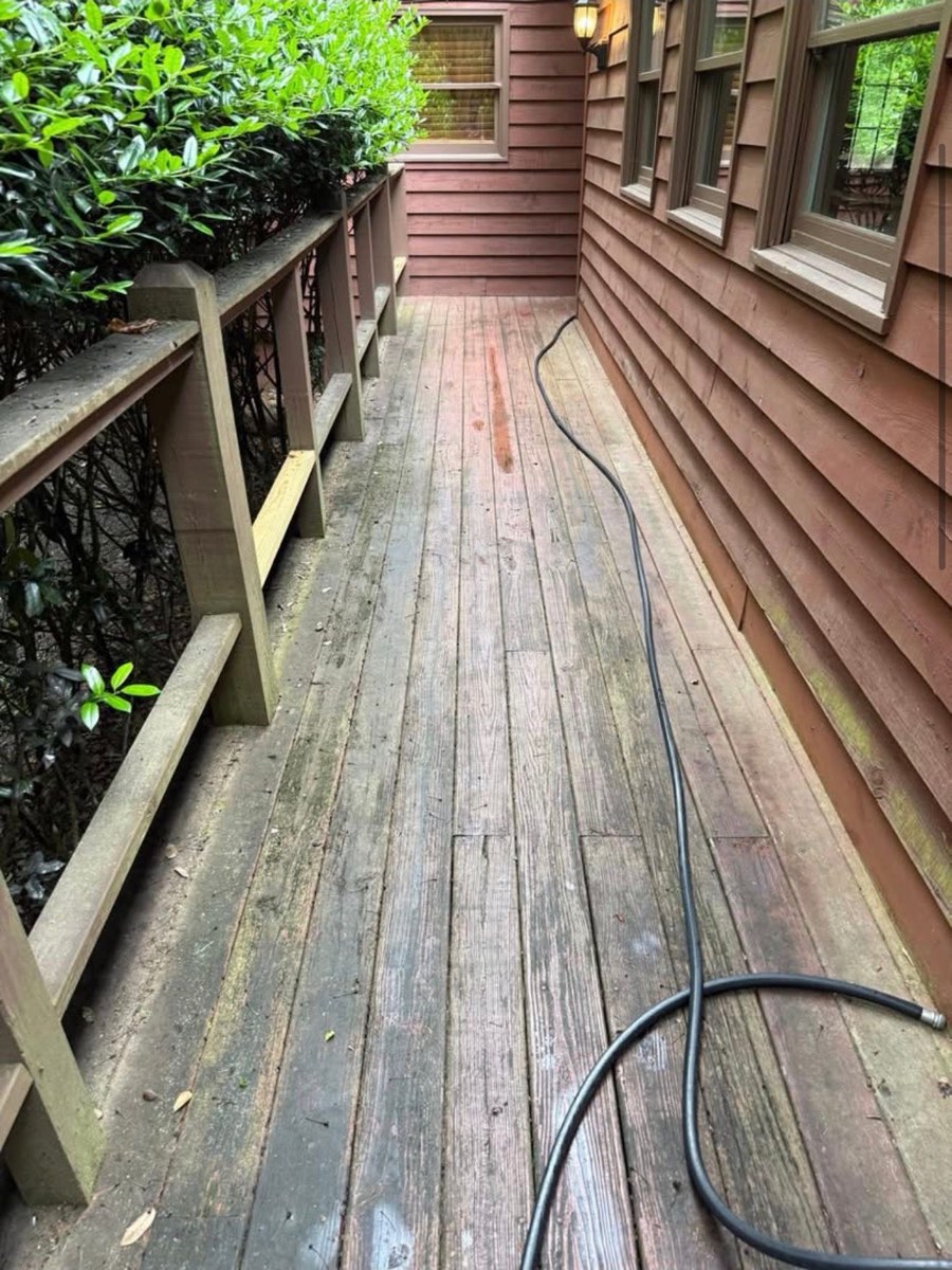 Before: grey, mildewed deck boards along the house
